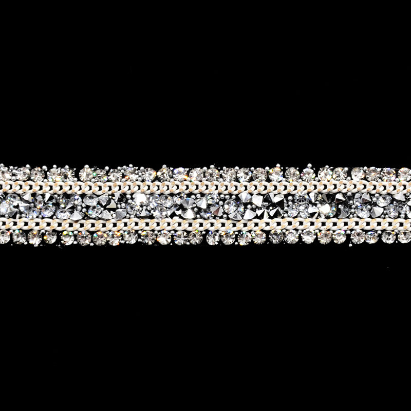 A close-up image of a beaded rhinestone trim with a shiny, metallic finish.