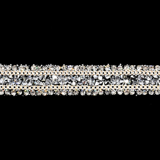 A close-up image of a beaded rhinestone trim with a shiny, metallic finish.