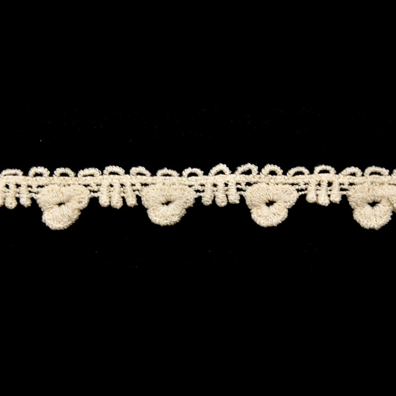 An ivory cotton lace trim with a floral pattern on a black background.