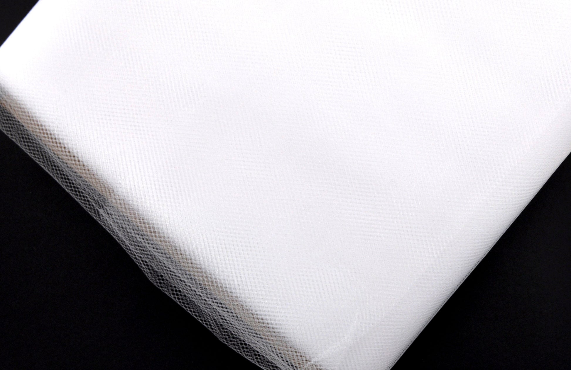 A bolt of white tulle fabric, 54 inches wide, on a plain background.